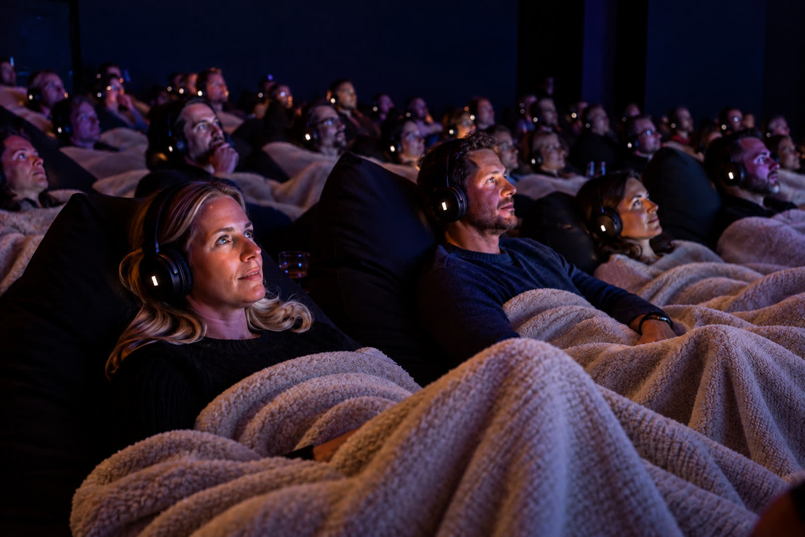 Deelnemers met headsets, warm belicht, onder witte dekens tijdens een No Escape Room sessie